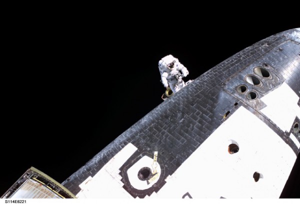 Steve Robinson works to remove a pair of protruding fabric gap fillers from Discovery's Thermal Protection System (TPS), during EVA-3. Photo Credit: NASA