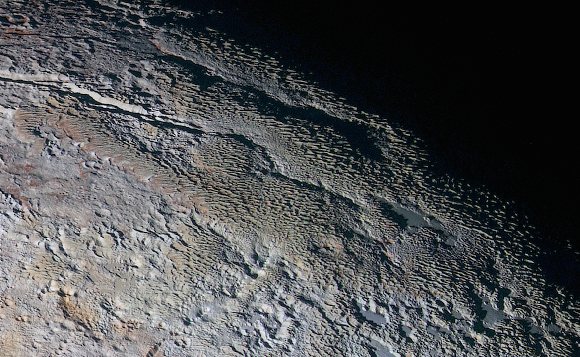 Extended color image showing the "snakeskin" terrain in the Tartarus Dorsa region, a mixture of blue-grey ridges and other reddish material. Image Credit: NASA/JHUAPL/SWRI