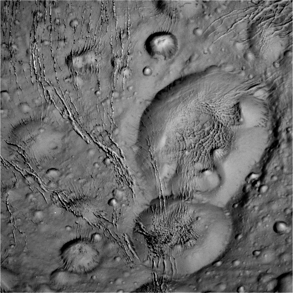 Raw image from the Oct. 14 flyby, showing craters and cracks in the icy surface. Image Credit: NASA/JPL-Caltech/Space Science Institute