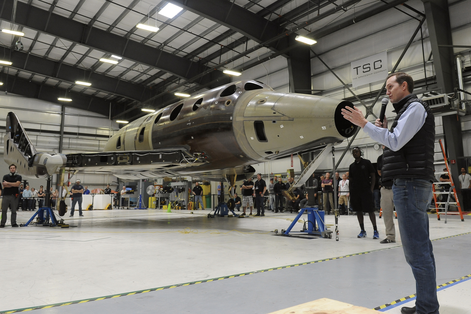 Virgin Galactic's CEO, George Whitesides, in front of the second SpaceShipTwo as he congratulates the team in Mojave after completing another important milestone in the process of assembling and integrating the second SpaceShipTwo - Weight on Wheels. Photo Credit: Virgin Galactic