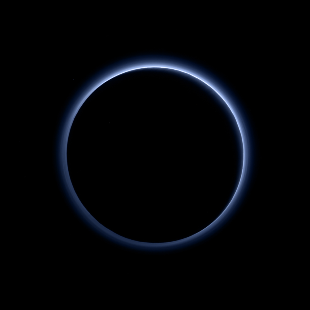 The blue skies of Pluto, as seen in this image from New Horizons. Pluto is backlit by the Sun, revealing the multilayered hazes in the atmosphere. Soot-like particles in the atmosphere scatter sunlight in a way that the atmosphere appears blue, similar to what happens on Earth. Image Credit: NASA/JHUAPL/SwRI