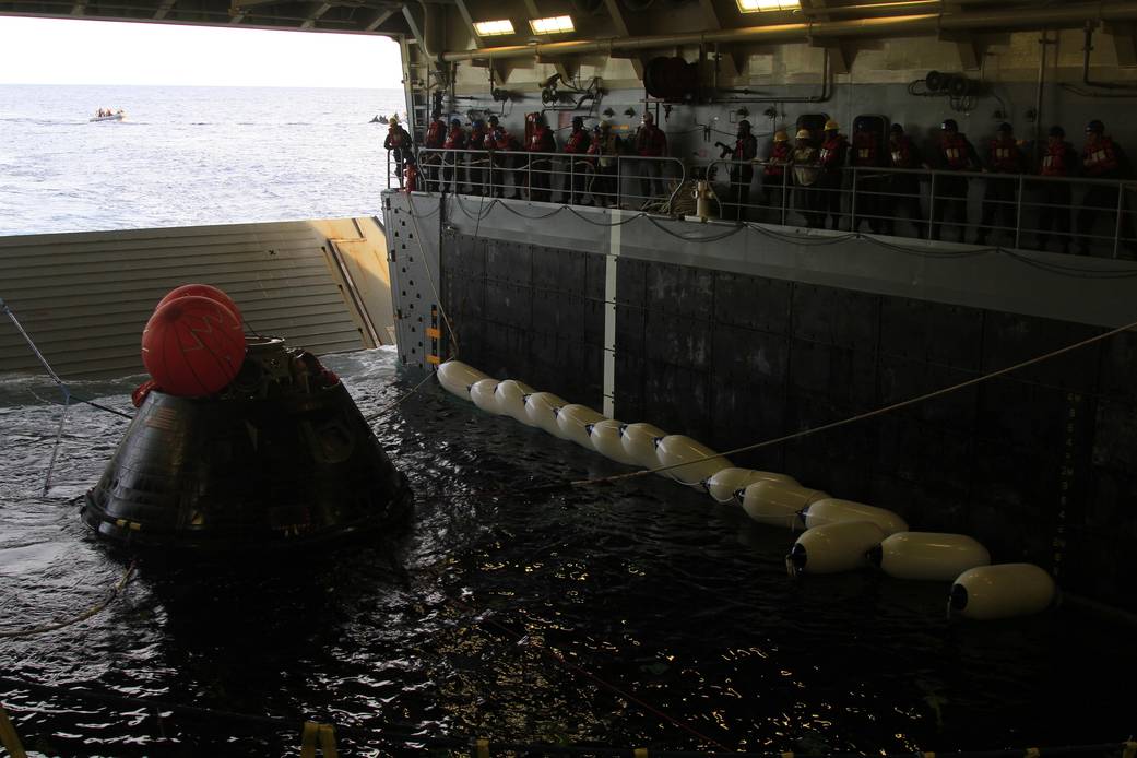 NASA’s Orion spacecraft is pulled safely into the well deck of the U.S. Navy’s USS Anchorage, following its splashdown in the Pacific Ocean. Caption and Credit: NASA