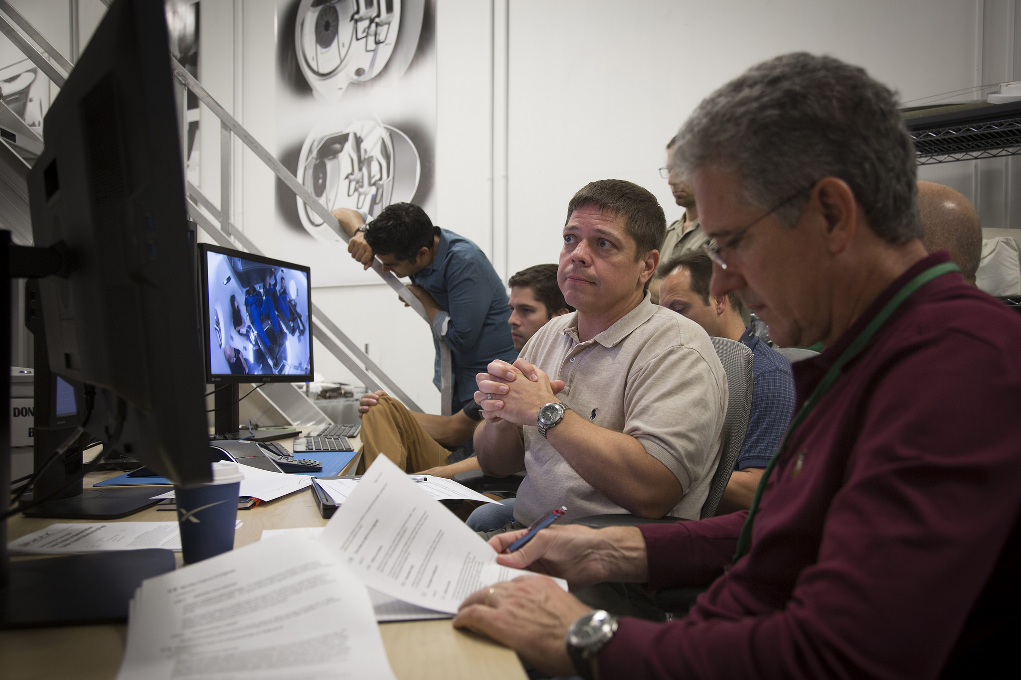 Commercial Crew astronaut Bob Behnken (center in beige shirt) watches monitors during an evaluation visit for the Crew Dragon spacecraft at SpaceX's Hawthorne, California, headquarters as astronaut Mike Good, right, looks on. Photo Credit: SpaceX