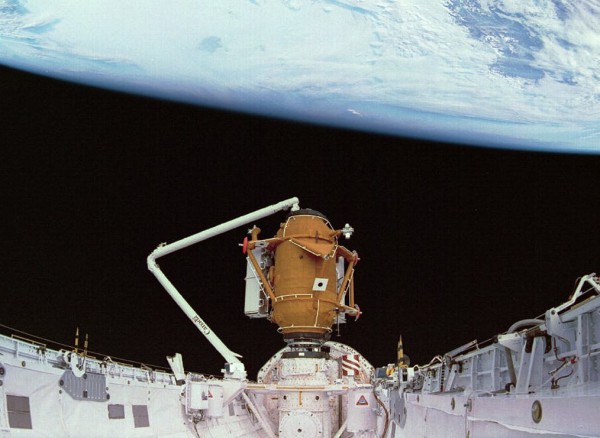 Becoming the first Canadian to operate the shuttle's Canadian-built Remote Manipulator System (RMS), Chris Hadfield installs the Docking Module (DM) atop the Orbiter Docking System (ODS), ahead of the shuttle's second docking mission to Mir, 20 years ago this month. Photo Credit: NASA, via Joachim Becker/SpaceFacts.de