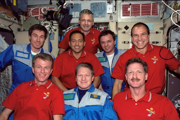 The STS-97 crew (in red shirts) and the Expedition 1 crew (in blue suits) pose for a group portrait. Front row (from left) are Brent Jett, Bill Shepherd and Joe Tanner, with Sergei Krikalev, Carlos Noriega, Yuri Gidzenko and Mike Bloomfield in the middle row and Marc Garneau at rear. Photo Credit: NASA, via Joachim Becker/SpaceFacts.de