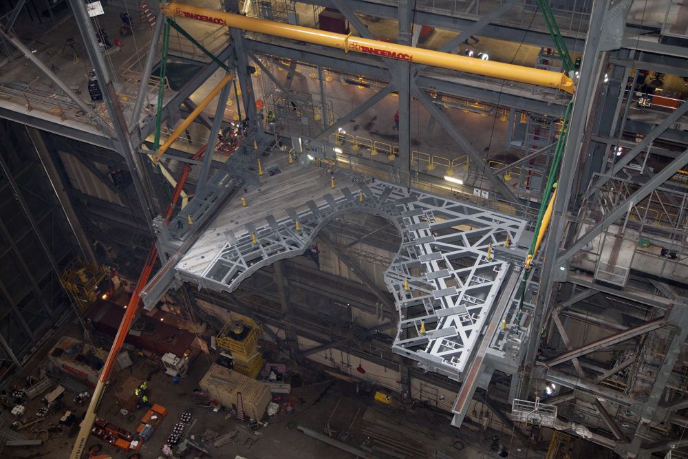 From NASA: "Inside the Vehicle Assembly Building at NASA's Kennedy Space Center in Florida, the 325-ton crane lifts the first half of the K-level work platforms up for installation in High Bay 3 on Dec. 22. The platform will be secured into position on tower E, about 86 feet above the floor." Photo Credit: NASA/Glen Benson