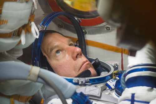 Tim Kopra, who will serve as part of the "second half" of Expedition 46, before commanding Expedition 47 in March-June 2016, participates in a suited fit-check aboard Soyuz TMA-19M. Photo Credit: NASA