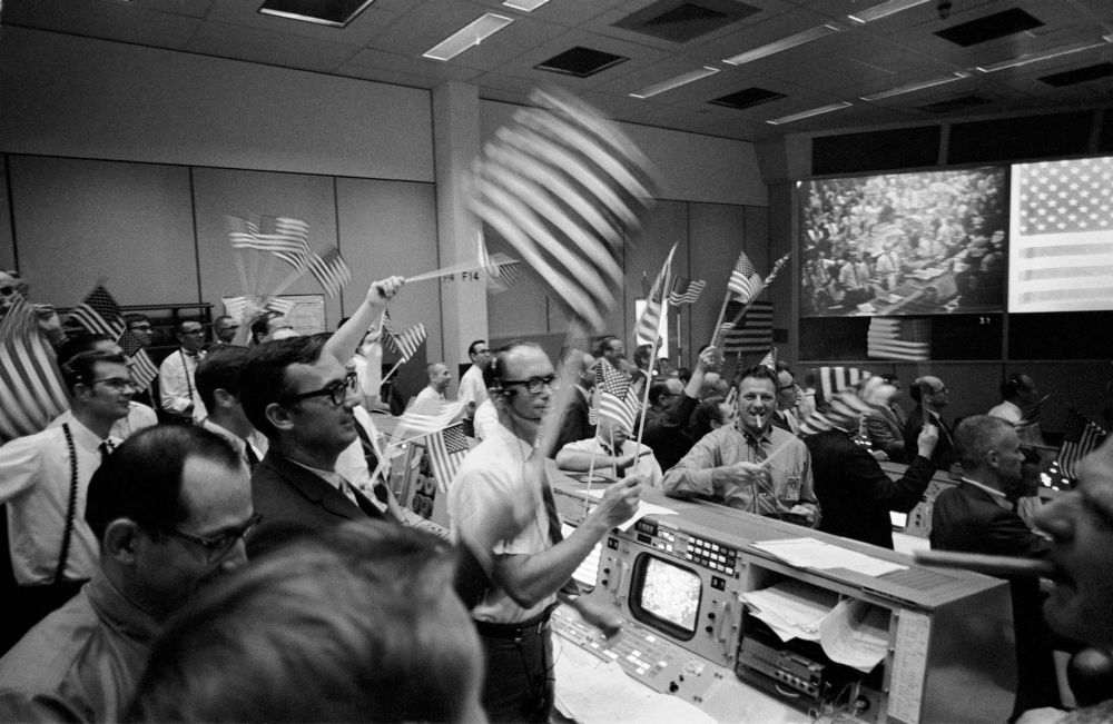 From NASA: "Overall view of the Mission Operations Control Room (MOCR) in the Mission Control Center (MCC), Building 30, Manned Spacecraft Center (MSC), showing the flight controllers celebrating the successful conclusion of the Apollo 11 lunar landing mission." Photo Credit: NASA