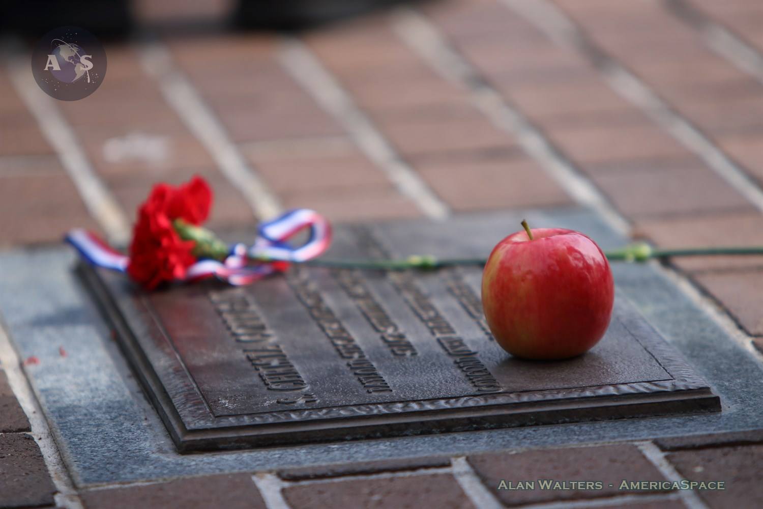 A single red carnation and, most touchingly, an apple decorate Christa McAuliffe's plaque at Titusville's Sand Point Park Saturday morning. Photo Credit: Alan Walters / AmericaSpace 