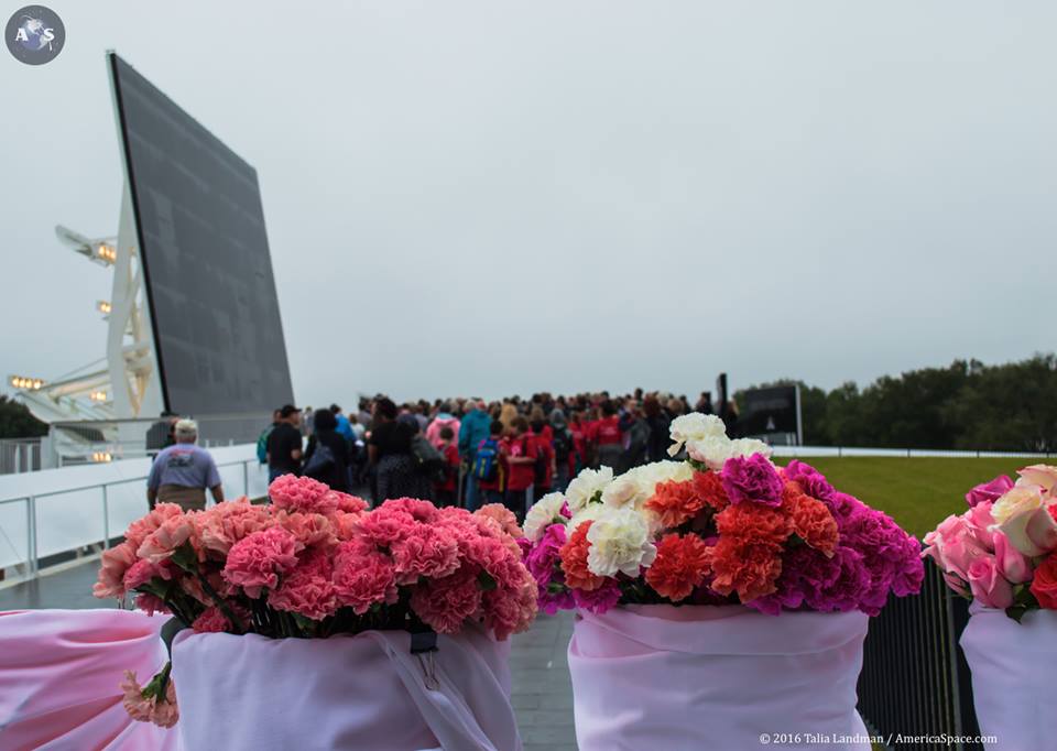 Floral tributes offer a touch of color against the drab grey and black of the Space Mirror Memorial and the day itself. Photo Credit: Talia Landman/AmericaSpace