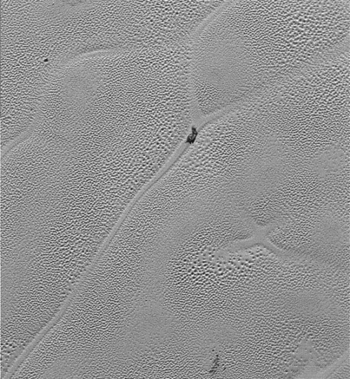 A lone "iceberg" of water ice floats in the nitrogen ice sea of Sputnik Planum. Photo Credit: NASA/JHUAPL/SwRI