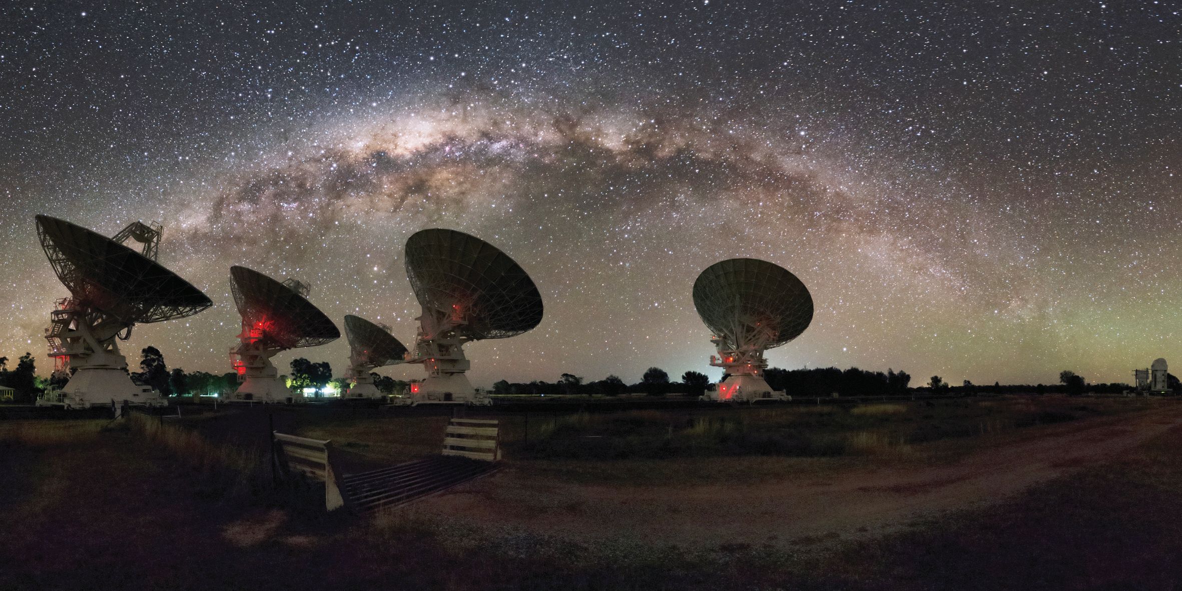 A composite image of the Milky Way above the Australia Telescope Compact Array, which has been utilised in the study of fast radio bursts in recent years. A series of recent discoveries, including the detection of the first-ever repeating fast radio burst, has added new layers to the existing mystery of this elusive cosmic phenomenon. Image Credit: Alex Cherney
