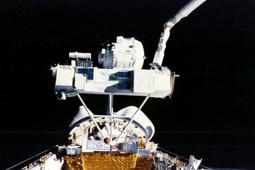 Characterized by its barrel-shaped cryostat, the Infrared Background Signature Survey (IBSS) and its Shuttle Pallet Satellite (SPAS) carrier are grappled by Discovery's mechanical arm. Photo Credit: NASA, via Joachim Becker/SpaceFacts.de
