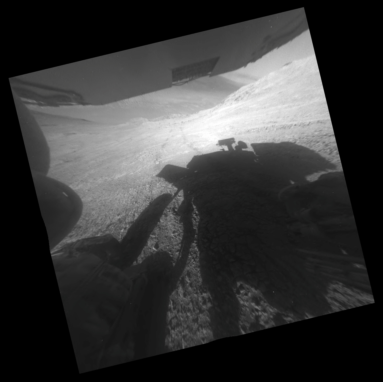 View from the Opportunity rover looking downhill from the steep hillside. Part of the floor of Endeavor crater can be seen beneath the underside of one of the solar panels. Image Credit: NASA/JPL-Caltech