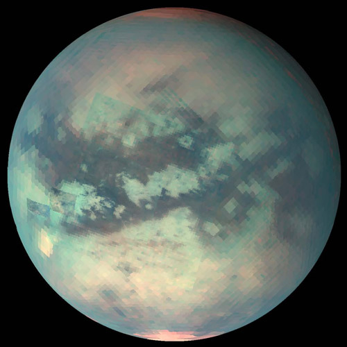 Titan, seen here in infrared to view the surface below the thick atmospheric haze, has methane fog, rain, rivers, lakes and seas. Image Credit: NASA/JPL/University of Arizona