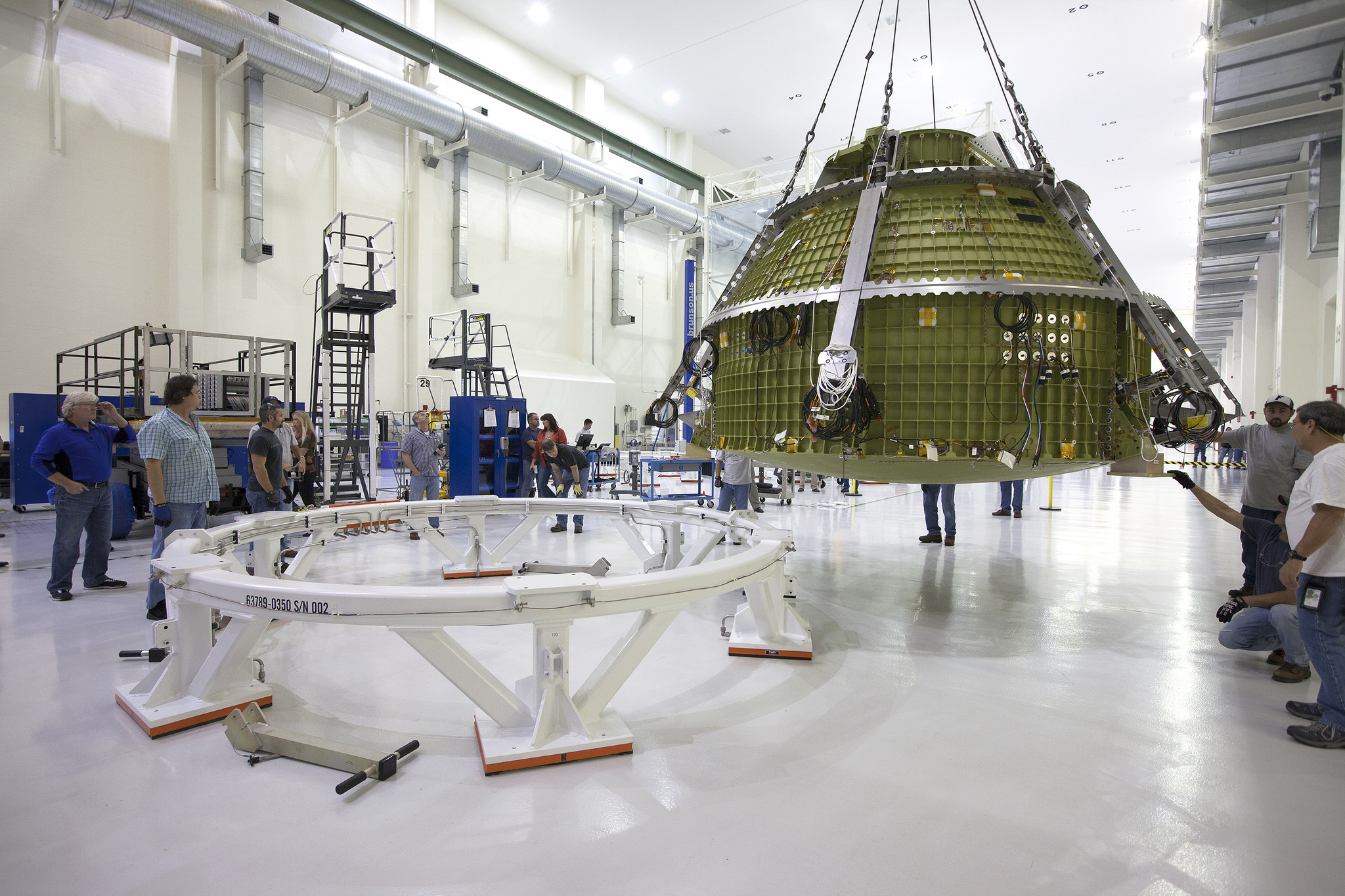 The Orion crew module pressure vessel for NASA’s Exploration Mission 1 (EM-1) is moved by crane along the high bay inside the Neil Armstrong Operations and Checkout Building at NASA’s Kennedy Space Center in Florida. The crew module was transferred to a proof pressure cell in the high bay for pressure checks. Photo Credit: NASA/Kim Shiflett
