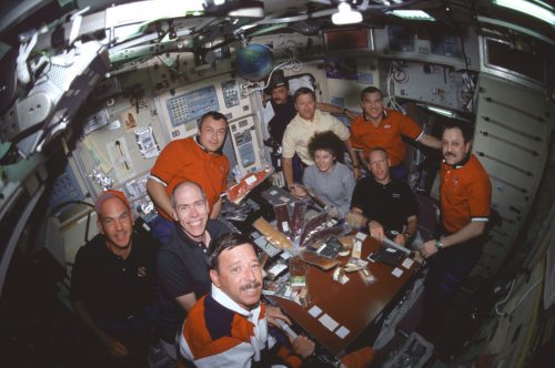 The combined STS-105, Expedition 2 and Expedition 3 crews assemble in the Zvezda service module aboard the International Space Station (ISS) for a joint meal. Photo Credit: NASA