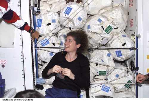 An amused Susan Helms floats in front of supplies and equipment newly moved over from the Leonardo Multi-Purpose Logistics Module (MPLM). Photo Credit: NASA