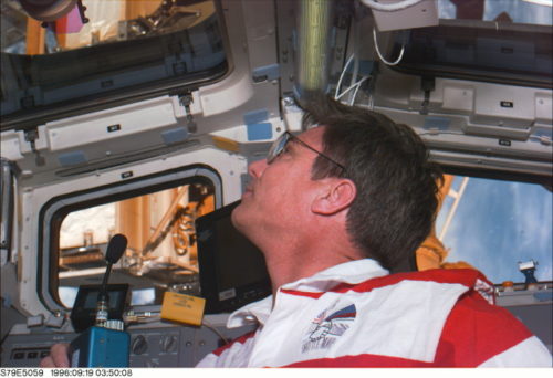 John Blaha gazes through Atlantis' overhead flight deck windows, shortly after docking with Mir. Photo Credit: NASA