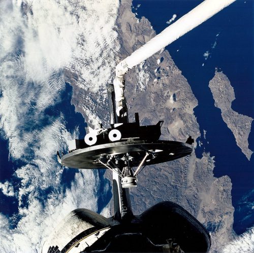 The Wake Shield Facility is prepared for deployment by Tom Jones and Columbia's Remote Manipulator System (RMS) mechanical arm. Photo Credit: NASA, via Joachim Becker/SpaceFacts.de