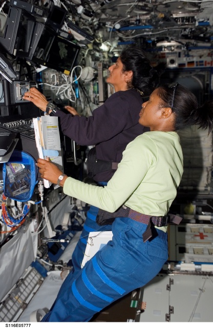 Joan Higginbotham (foreground) and Sunita Williams at work aboard the space station during STS-116. Photo Credit: NASA