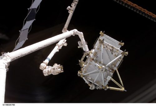 Affectionately nicknamed "Puny" by the crew, the P-5 truss acted as a structural spacer between the solar-array-bearing P-4 and P-6 hardware. It is here pictured being "handed-off" from Discovery's mechanical arm to the station's Canadarm2. Photo Credit: NASA